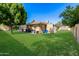 Expansive backyard with lush green lawn, mature trees, and a patio area perfect for entertaining at 7802 N 6Th St, Phoenix, AZ 85020