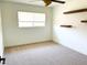 Bright bedroom with neutral carpet, wooden floating shelves, and a large window at 7802 N 6Th St, Phoenix, AZ 85020