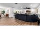 Open-concept living area with seamless flow, featuring wood-look tile flooring, and an oversized sofa at 7802 N 6Th St, Phoenix, AZ 85020