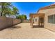 Gravel backyard with a covered patio, block fence and shade trees at 8321 W Hughes Dr, Tolleson, AZ 85353
