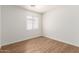 Bright bedroom with light-toned hardwood floors and a window with white blinds at 8321 W Hughes Dr, Tolleson, AZ 85353