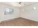 Bright bedroom with wood floors, a ceiling fan, and multiple windows creating a serene atmosphere at 8321 W Hughes Dr, Tolleson, AZ 85353