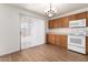 Well-lit kitchen with laminate floors, wood cabinetry, a chandelier, and a sliding door to the backyard at 8321 W Hughes Dr, Tolleson, AZ 85353