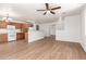 The open concept living space has wood flooring, a ceiling fan, and views of the kitchen area at 8321 W Hughes Dr, Tolleson, AZ 85353