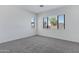 Well-lit bedroom with neutral carpet and large windows providing natural light at 8350 W Carole Ln, Glendale, AZ 85305