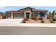 Charming home with a two-car garage, beautiful stone accents, and professionally landscaped front yard at 8350 W Carole Ln, Glendale, AZ 85305