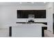 Bright and spacious kitchen with a large center island, dark cabinets, and modern stainless steel appliances at 8350 W Carole Ln, Glendale, AZ 85305