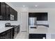 Modern kitchen with dark cabinetry, stainless steel appliances, a center island, and white countertops at 8350 W Carole Ln, Glendale, AZ 85305