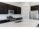 Well-equipped kitchen featuring stainless steel appliances, a large center island, and stylish dark cabinets at 8350 W Carole Ln, Glendale, AZ 85305