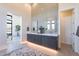 Modern bathroom featuring double vanity with gray cabinets and stylish mirrors, tiled accent wall, and an inviting open space at 8366 E Old Paint Trl # 3, Scottsdale, AZ 85266