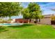 Lush backyard with a sparkling pool, mature fruit trees, and a well-maintained lawn providing a serene outdoor oasis at 9008 N 83Rd St, Scottsdale, AZ 85258