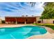 Refreshing backyard featuring a private pool, covered patio, and lush green lawn perfect for outdoor enjoyment at 9008 N 83Rd St, Scottsdale, AZ 85258