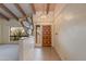 Inviting foyer with a wooden front door, unique art piece, and wood-beamed ceilings offering a warm welcome at 9008 N 83Rd St, Scottsdale, AZ 85258