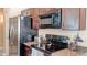 Close-up on modern kitchen appliances: stainless steel refrigerator, oven, and microwave at 9248 E Blanche Dr, Scottsdale, AZ 85260