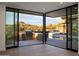 Stunning backyard with pool, outdoor kitchen, and desert views visible through sliding glass doors at 9750 E Troon North Dr, Scottsdale, AZ 85262