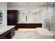 A modern bathroom features a double vanity, illuminated mirrors, a standalone tub, and a glass-enclosed shower at 9750 E Troon North Dr, Scottsdale, AZ 85262