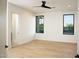 A bright, empty bedroom with hardwood floors, two windows, and a ceiling fan at 9750 E Troon North Dr, Scottsdale, AZ 85262