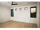 A large empty bedroom with hardwood floors and desert views from the black-trimmed windows at 9750 E Troon North Dr, Scottsdale, AZ 85262