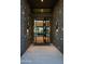 Open glass door showcasing a view into the home with stone walls and travertine tiled flooring at 9750 E Troon North Dr, Scottsdale, AZ 85262