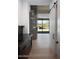 Hallway with stone accent wall, wood floors, and a view to the outdoor living space at 9750 E Troon North Dr, Scottsdale, AZ 85262