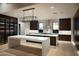 Modern kitchen with double islands, dark wood cabinets, stainless steel appliances, and stunning sunset views at 9750 E Troon North Dr, Scottsdale, AZ 85262