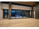 Spacious living room boasting wood floors, stone accents, and panoramic glass doors to the patio at 9750 E Troon North Dr, Scottsdale, AZ 85262