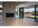 Open living room featuring a stone fireplace, and sliding glass doors with outdoor views at 9750 E Troon North Dr, Scottsdale, AZ 85262