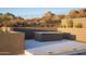 A modern desert oasis features a built-in outdoor fireplace and landscaped grounds at 9750 E Troon North Dr, Scottsdale, AZ 85262