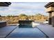 A sleek pool with a water feature harmonizes with the natural desert landscape at 9750 E Troon North Dr, Scottsdale, AZ 85262