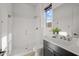 Bright bathroom featuring a glass shower, modern vanity, and natural light from the window at 10127 E Tillman Ave, Mesa, AZ 85212