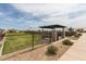 Fenced dog park with green space, seating area, and shade structure for a comfortable environment at 10127 E Tillman Ave, Mesa, AZ 85212