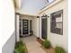 Inviting front porch with modern black door, sidelight windows, and stylish outdoor decor and landscaping at 10127 E Tillman Ave, Mesa, AZ 85212