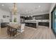 Spacious kitchen and dining area with an island, dark cabinets, stainless appliances, and elegant chandelier lighting at 10127 E Tillman Ave, Mesa, AZ 85212