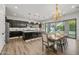 Open-concept kitchen and dining area featuring a large island, dark cabinetry, and sliding glass doors to the backyard at 10127 E Tillman Ave, Mesa, AZ 85212