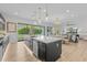 Open-concept kitchen with stainless appliances, expansive island, and seamless connection to dining and living areas at 10127 E Tillman Ave, Mesa, AZ 85212