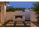 Outdoor fireplace with stone accents and built-in seating, creating a cozy focal point in the yard at 10127 E Tillman Ave, Mesa, AZ 85212