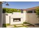 An outdoor fireplace with wood provides warmth and ambiance in the backyard at 10127 E Tillman Ave, Mesa, AZ 85212