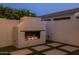 Cozy outdoor fireplace with stacked logs, creating an inviting atmosphere in the backyard at 10127 E Tillman Ave, Mesa, AZ 85212