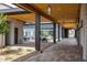 Inviting outdoor patio with a wood-covered walkway, seating areas, and an adjacent dining space under umbrellas at 10127 E Tillman Ave, Mesa, AZ 85212