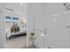 Bright view of a seamless glass walk-in shower and a glimpse into the cozy main bedroom at 10127 E Tillman Ave, Mesa, AZ 85212