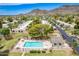 Aerial view of sparkling pool with lounge chairs and mountain views and well-kept landscaping under a clear, blue sky at 10215 N 8Th St # B, Phoenix, AZ 85020