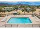 Aerial view of sparkling pool with lounge chairs and mountain views and well-kept landscaping under a clear, blue sky at 10215 N 8Th St # B, Phoenix, AZ 85020