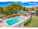 Aerial view of sparkling pool with lounge chairs, umbrellas, a picnic area, and well-kept landscaping under a clear, blue sky at 10215 N 8Th St # B, Phoenix, AZ 85020