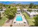 Aerial view of sparkling pool with lounge chairs and mountain views and well-kept landscaping under a clear, blue sky at 10215 N 8Th St # B, Phoenix, AZ 85020