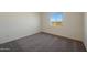 Bedroom featuring neutral tones, carpet floors, and view from the window showing the desert landscape at 1074 W West Virginia Ave, Florence, AZ 85132