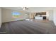 Spacious living room with plush carpeting, a ceiling fan, and seamless transition to the kitchen area at 1074 W West Virginia Ave, Florence, AZ 85132