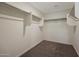 Walk-in closet equipped with shelving units and carpet flooring for optimal storage at 1074 W West Virginia Ave, Florence, AZ 85132