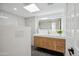 Modern bathroom with double sinks, wood cabinets, stylish mirror and light fixture at 11079 N 110Th Pl, Scottsdale, AZ 85259