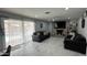 Cozy living room with a stone fireplace, tile flooring, and sliding door access to the pool at 11250 N 33Rd Ave, Phoenix, AZ 85029