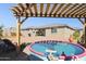 View of the backyard featuring a pergola, stock tank pool, fire pit and desert landscaping at 12176 E Chevelon Trl, Gold Canyon, AZ 85118